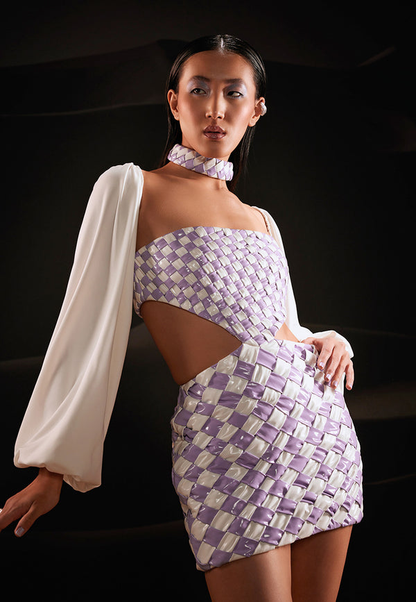This stunning cut-out mini dress is skillfully constructed using soft artificial leather in lilac and white hues. It features a diamond-weave techquine all over the garment with cut-outs on the waist and a sqaure neckline. Hooks and eyes are used as closures at center back and a metal zipper on the side. White long puffed sleeves using lush lycra crepe fabric are attached to complete the whole look. Wear it for a girl's night out or a soiree with heeled sandals and silver accessories.