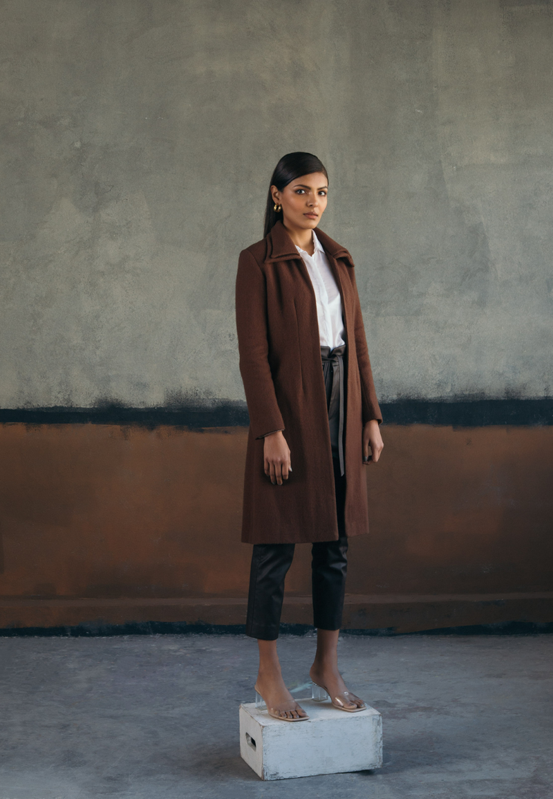 This woman’s brown double collared wool coat is chic and versatile. Crafted from plush wool, the wool jacket features a double collar with princess lines in the front for a more fitted look. This knee-length coat is a definite style statement for the winters. The easy and comfortable fit on the front make it perfect and versatile for layering over anything.