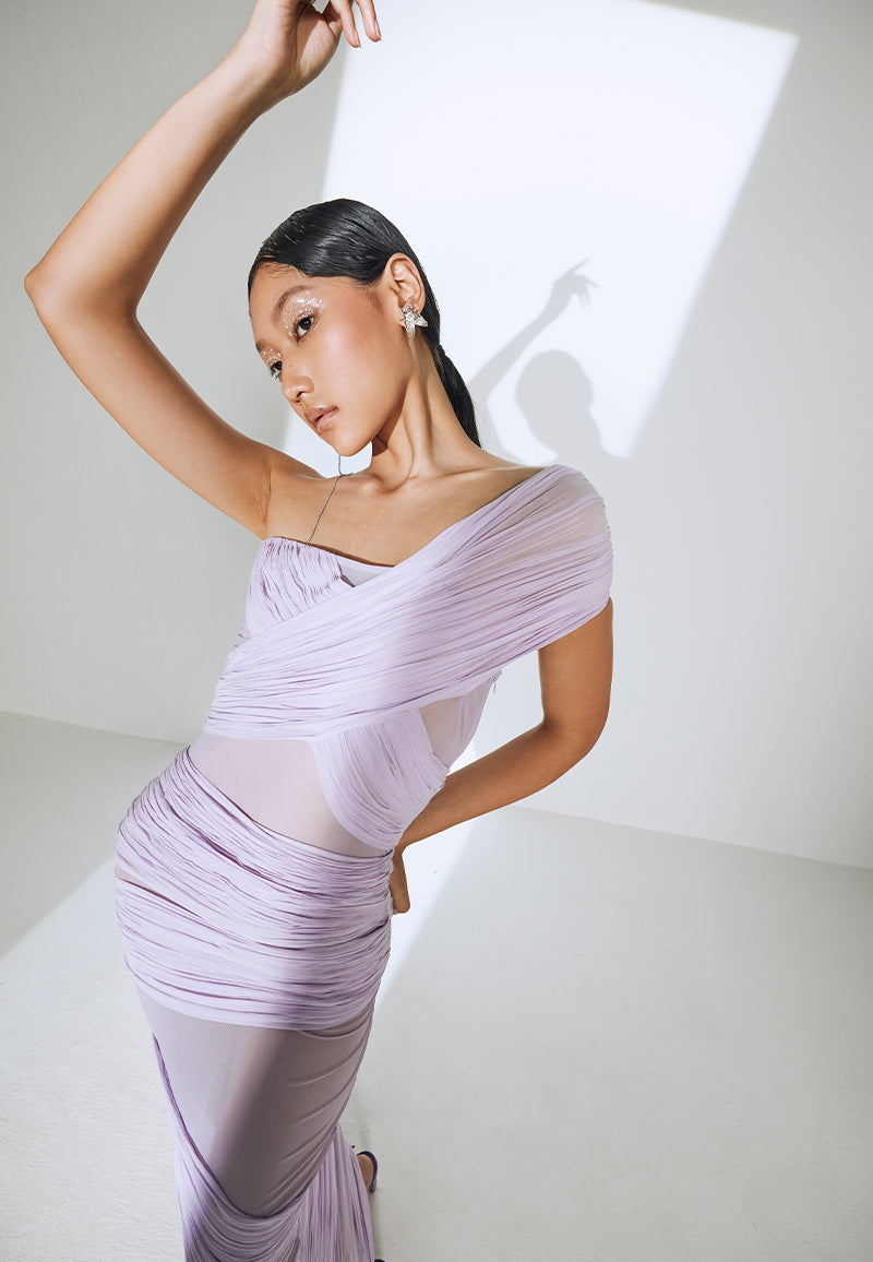 Ruched and wrapped in lycra georgette, this one-shoulder, bodycon cocoon dress is made to accentuate your body features. This draped, bandage dress is constructed in our lightest hue, lilac and falls to the ankle. The dress features a zip closure on the side seam. Wear it at your bacheloratte or a girls' night out with a pair of heeled sandals and minimal jewelry.