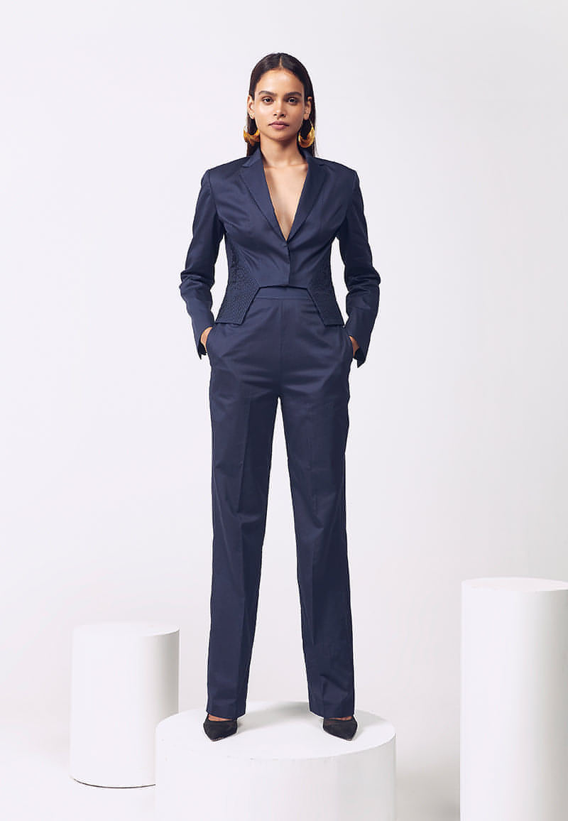 Mannat Gupta's premuim collection of women's co-ord sets. This jacket and pant co-ord set is made is soft cotton satin in navy blue. The collared cropped jacket with hidden buttons on the front features long sleeves and hand pleating details on both sides that accentuate a woman's body. The navy blue jacket comes with a high-waisted flared pant with inseam pockets for functionality in the same color. Pair yours with pumps and minimal, versatile gold jewelry for your next meeting or work.
