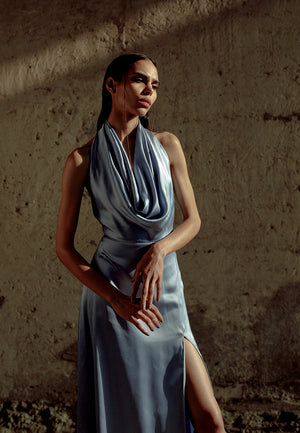 Mannat Gupta’s mini and maxi dresses collection. Shine like a star with our icy blue maxi dress. This turquoise color will add more value to your party look. Made  with glossy silk satin with an alluring cowl neckline and an undulating high-slit cut that 