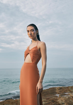 Ruched in lightweight pure crepe, this backless, halter neck clay maxi is an easy, breezy choice for a day out in the city. The maxi features gathered ruching on the chest area with an interesting cut-out detail at the center front of the waist.