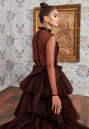 This detachable wine ruffled gown is modernized through an intriguing juxtaposition of layers and transparencies that gives it an ethereal feel. This expertly crafted ensemble with a special layered ruched detachable trail, ruched bodysuit and gathered mi