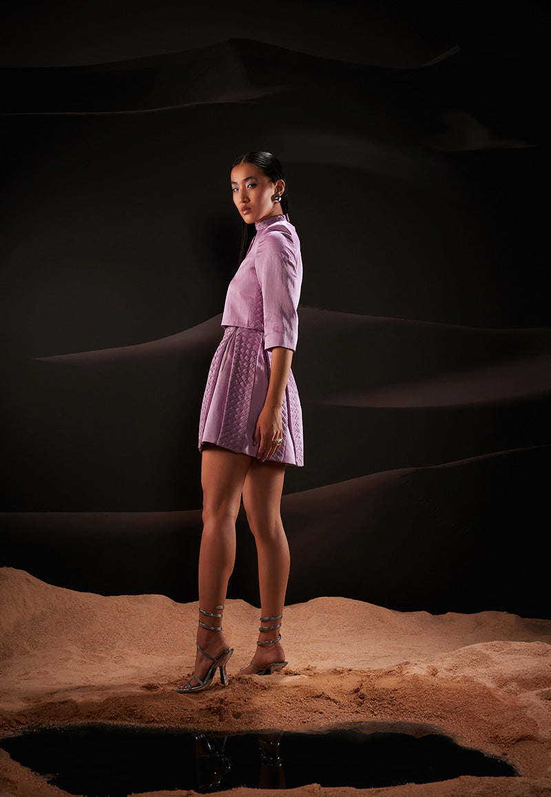 This beautifully handcrafted 3-piece co-ord set is designed to create an impact wherever you go. It features a weaved bandeau top, high-waisted box pleated skirt accompanied with a short jacket with a round neckline in pastel violet offering a flawless and tempting look. The ensemble is cut from hand-dyed linen satin fabric giving it a luxurious and comfortable look. Pair yours with strappy sandals and gold jewellery to amplify the look.