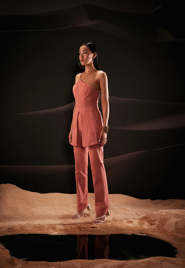 Epitome of sophistication and modern allure, this halterneck co-ord set is cut from durable cotton in coral shade. This ensemble brings a sense of adventure wherever you go with weaved and plain panels on the top with a slit at the center front and a gold metal zipper at the center back. The straight, high-waisted pants in the same hue complete the look. Pair yours with wedges or strappy sandals and gold accessories for a finished look.