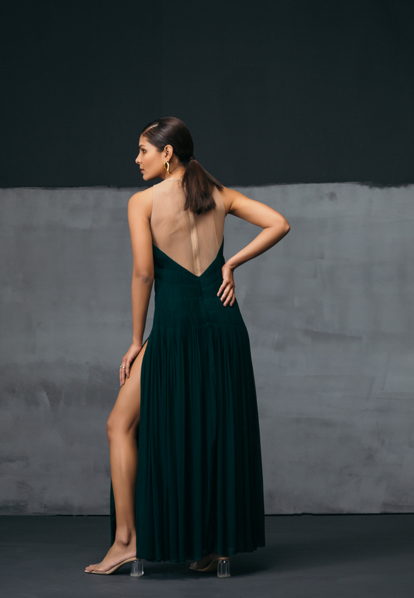 Decore yourself with our long maxi dress which is made from georgette. The green maxi dress features cut out on both sides and intricate pleating on the back. In addition, a head-turning sleeveless design makes this perfect for all the seasons. Walk like a queen with floor-skimming hem and dramatic splits with a bodycon appeal. Pair with round shapes earrings and high heel sandals