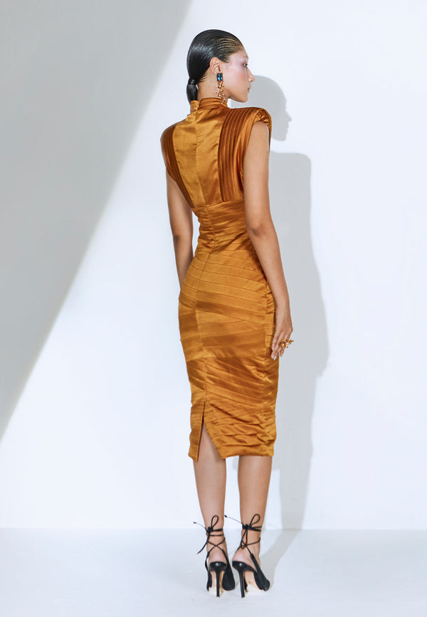 Designed to create a statement, this bodycon bandage dress in rustic gold is cut and constructed using lush satin. The sleeveless midi dress features criss-cross bandage draping with exaggerated shoulder padding and a pleated turtle neck. It has a zip closure at the center back and a flap opening at the back hem for easy movement. It is the perfect dress for your next formal dinner, date night, red carpet or a soiree. Pair yours with heeled sandals or pumps and long gold earrings to complete the look.
