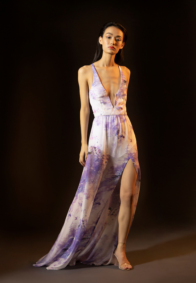 Women's new purple and white printed long maxi dress is made from airy sheer chiffon. This floor-length tie-dye dress is perfect for summer days and parties at the beach. The maxi features a plunging neckline on the front and a crossback neckline on the back along with a thigh-high slit. The sheer printed dress comes with a white bodysuit attached inside for coverage. Pair the dress with heels or flats to complete the look.