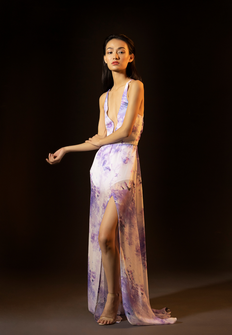 Women's new purple and white printed long maxi dress is made from airy sheer chiffon. This floor-length tie-dye dress is perfect for summer days and parties at the beach. The maxi features a plunging neckline on the front and a crossback neckline on the back along with a thigh-high slit. The sheer printed dress comes with a white bodysuit attached inside for coverage. Pair the dress with heels or flats to complete the look.