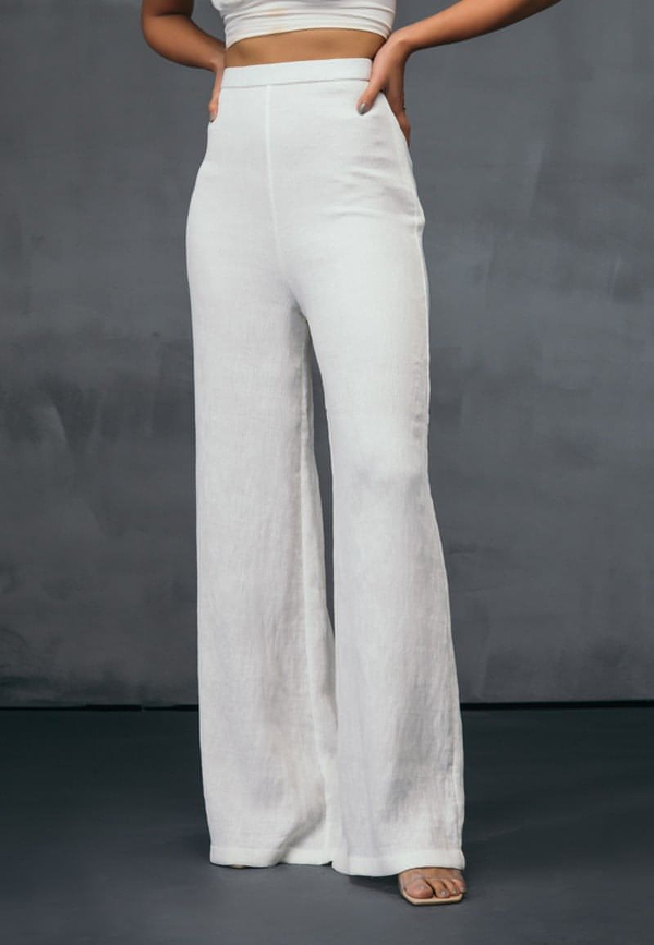 These high-waisted flared pants in white are must have for all the seasons. Crafted from stretchable pre-pleated jersey knit, this style sits high on the waist. Style yours with a crisp shirt or a crop top for the summers or spring. Or style the pants with your favorite coat or jacket for the fall or winters.