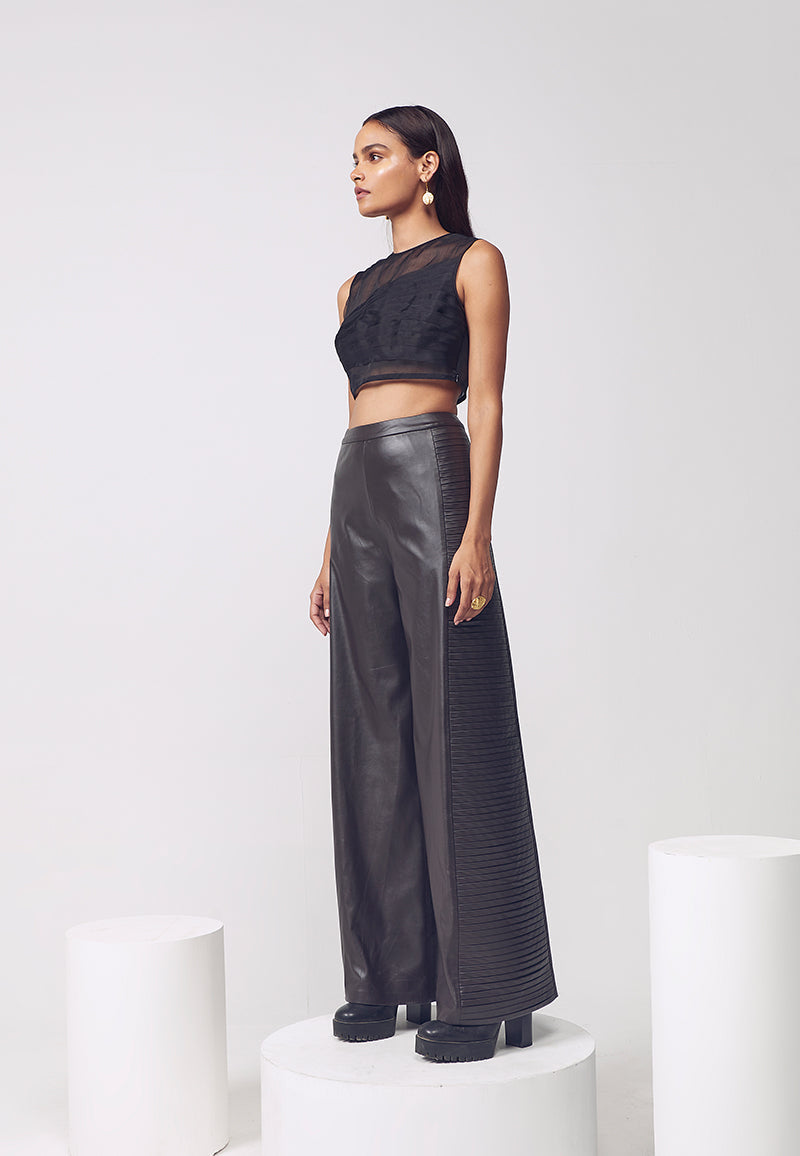 This caramel brown flared leather pants with horizontal pleat detail on the side seams give structure and adds volume to these comfortable pants. This pant is crafted in artificial leather and sits high on waits and falls to the floor. Pair it with a crop top, bustier or corset in the summers or a sweater in the winters for versatile, minimal looks.