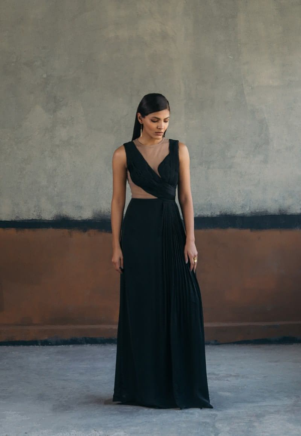 Woman's maxi dress crafted from black satin crepe fabric is a must-have for the evenings. This sleeveless floor-length gown features delicately draped ruching and pleating details with a sheer back made out of net. Style it with minimal gold jewelry and heeled sandals for an elevated look.