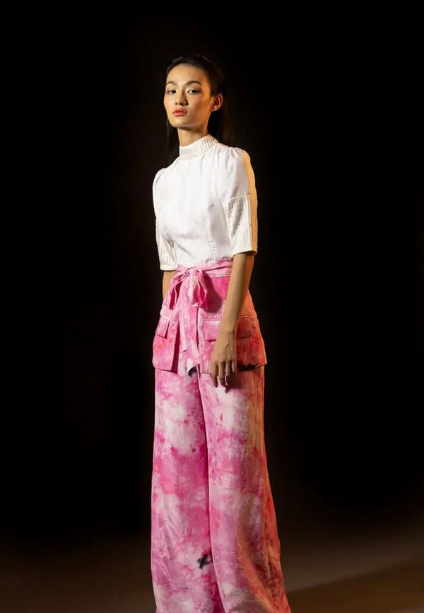 This beautiful tie-dyed high-waisted pants made from lustrous silk is sure to grab attention. Wear it in the summers, spring or fall for its tonal pink and white hues. Skirt and flap pockets in the front is highlight of the ensemble. These pants are perfect for all the seasons and can be paired and layered with almost anything.