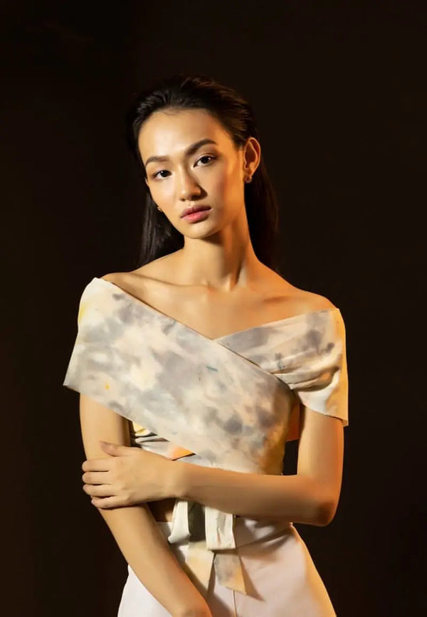 Mannat Gupta's collection of women's crop tops. This off-shoulder crop top is made using silk in a tie dye print of yellow and grey. The wrap-around style makes the half sleeves crop top functional and appealing. Pair the top with pants, jeans or shorts with sneakers or heels for your next brunch or dinner. 